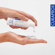 Load image into Gallery viewer, Curaprox Aligner Foam onto a clear dental aligner. The foam is dispensed from a white bottle labelled "Swiss Premium Oral Care." CURAPROX branding is visible on a clean white background.