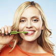 Load image into Gallery viewer, TePe Select Medium Toothbrush with tapered head in use by smiling woman.