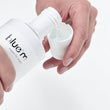 Load image into Gallery viewer, blue®m Oxygen Fluid being poured into its measuring cap
