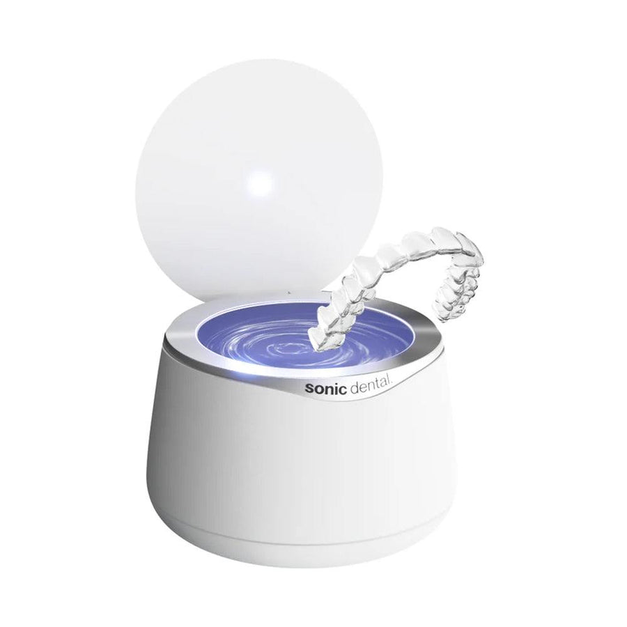White Sonic Pro dental appliance cleaner with open lid full of water with clear aligner.