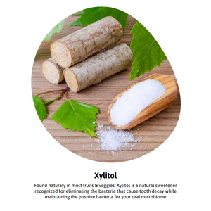 Dr Heffs Remarkable Xylitol powder next to birch bark on wooden background with green leaves.